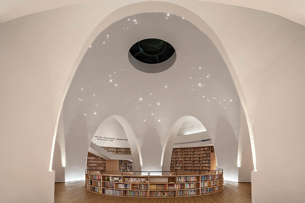 A dramatic archway with star constellations softly illuminated creates a canopy for the books below.