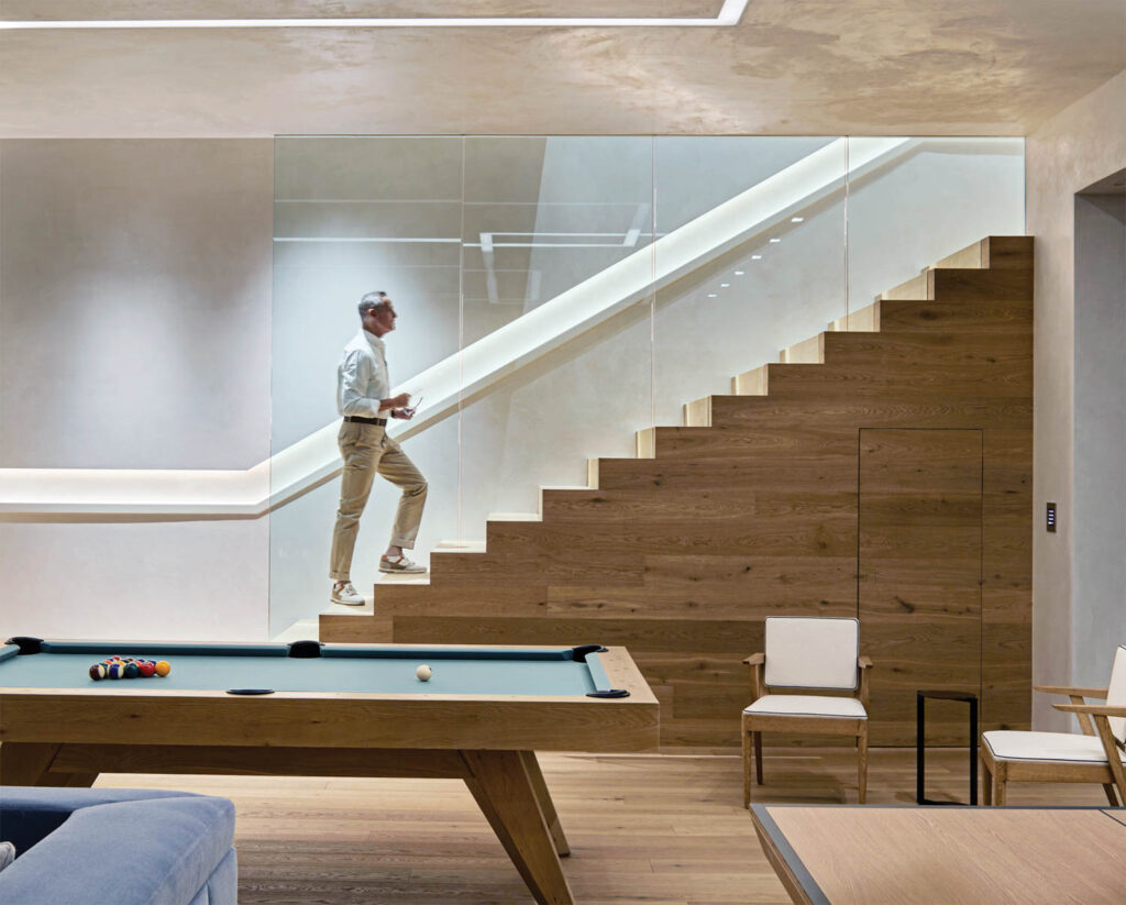 a man walks up the stairs from a rec room inside a Colorado home