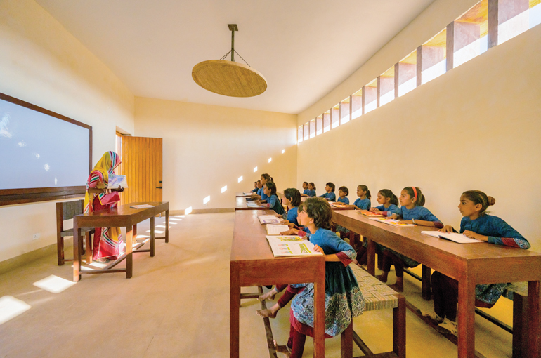 Students sit at teak desks in a classroom at the Rajkumari Ratnavati Girls’ School