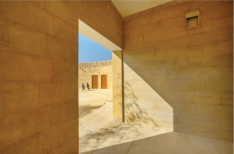 The sunlight stream through a brick and sandstone room that opens to the courtyard