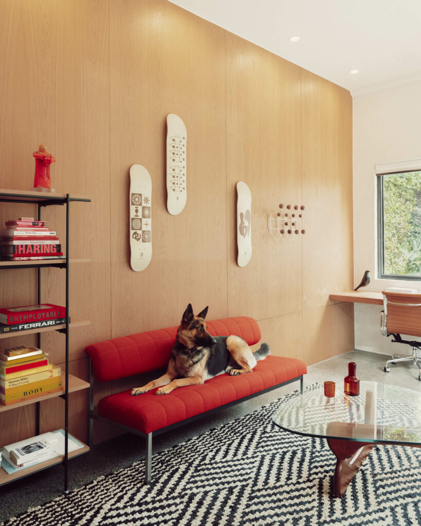 a dog sits below the Silhouette Deck Plywood Sculpture by Eames and Globe