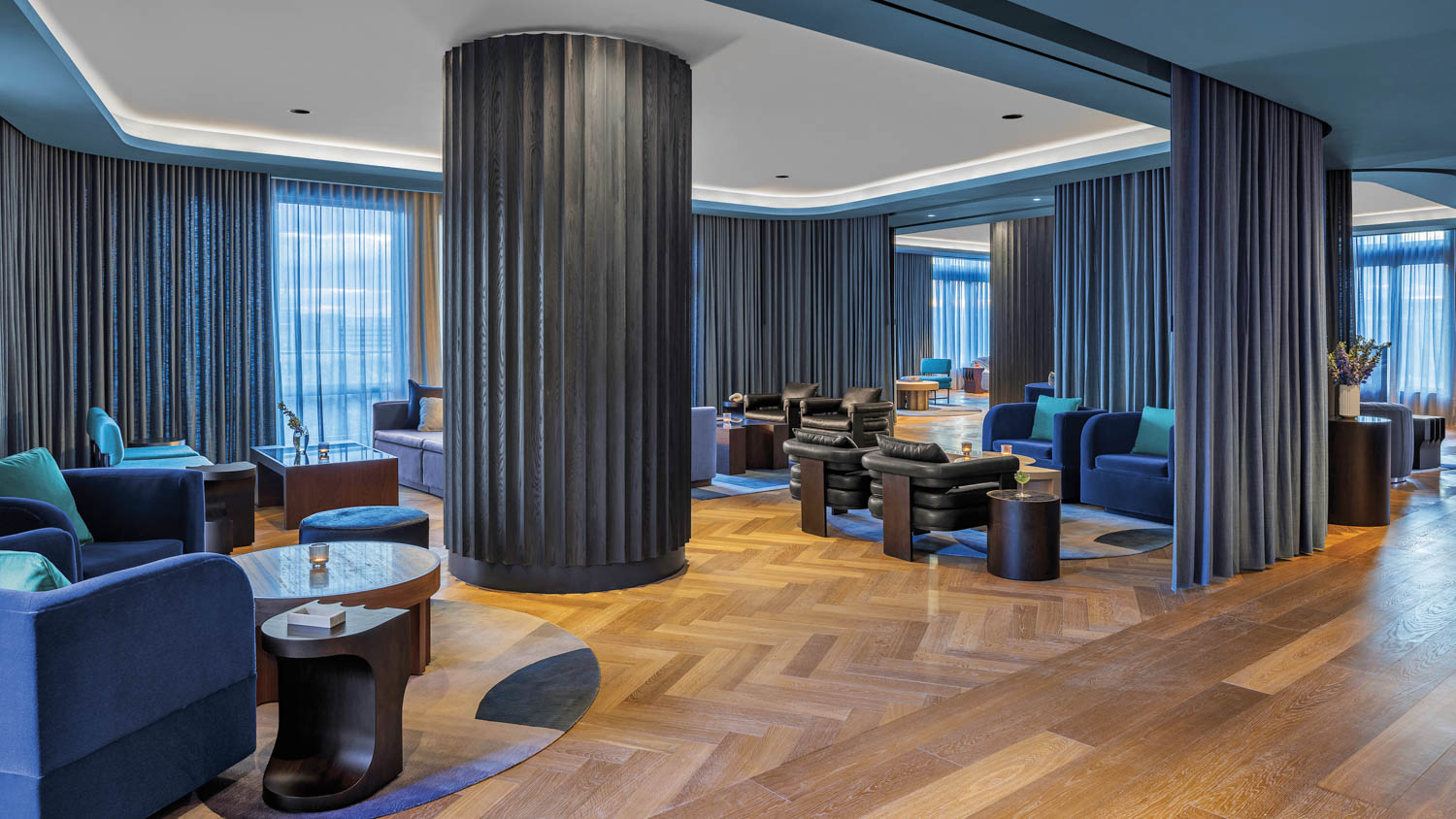 a lounge with midnight blue furniture and furnishings in The Morrow, a Hilton hotel