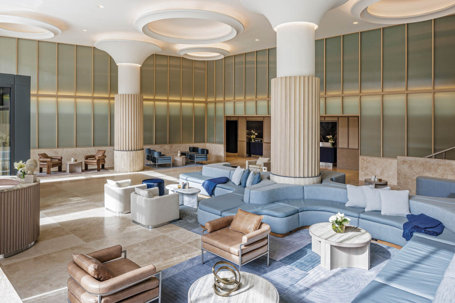 a hotel's lounge area with light blue seating and tan accents