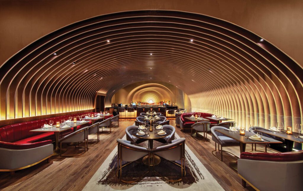 The casual bistro and bar, framed by a tunnel that results from the fins, with walnut flooring and custom furnishings.