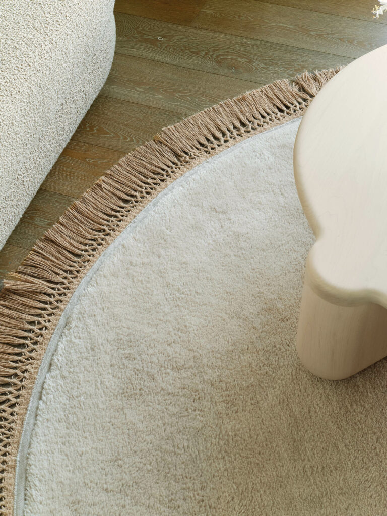 a cream-colored mohair rug with a jute fringe
