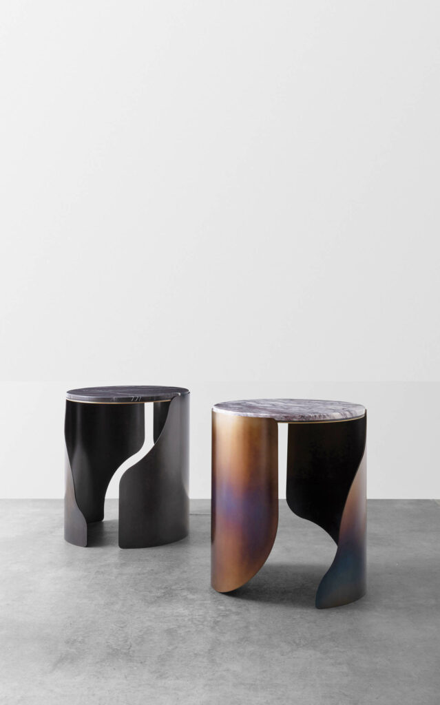 Two stools in black and bronze with a white geometric pattern on the side
