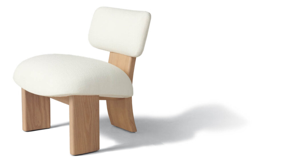 A chair with white cushions and curved wooden legs
