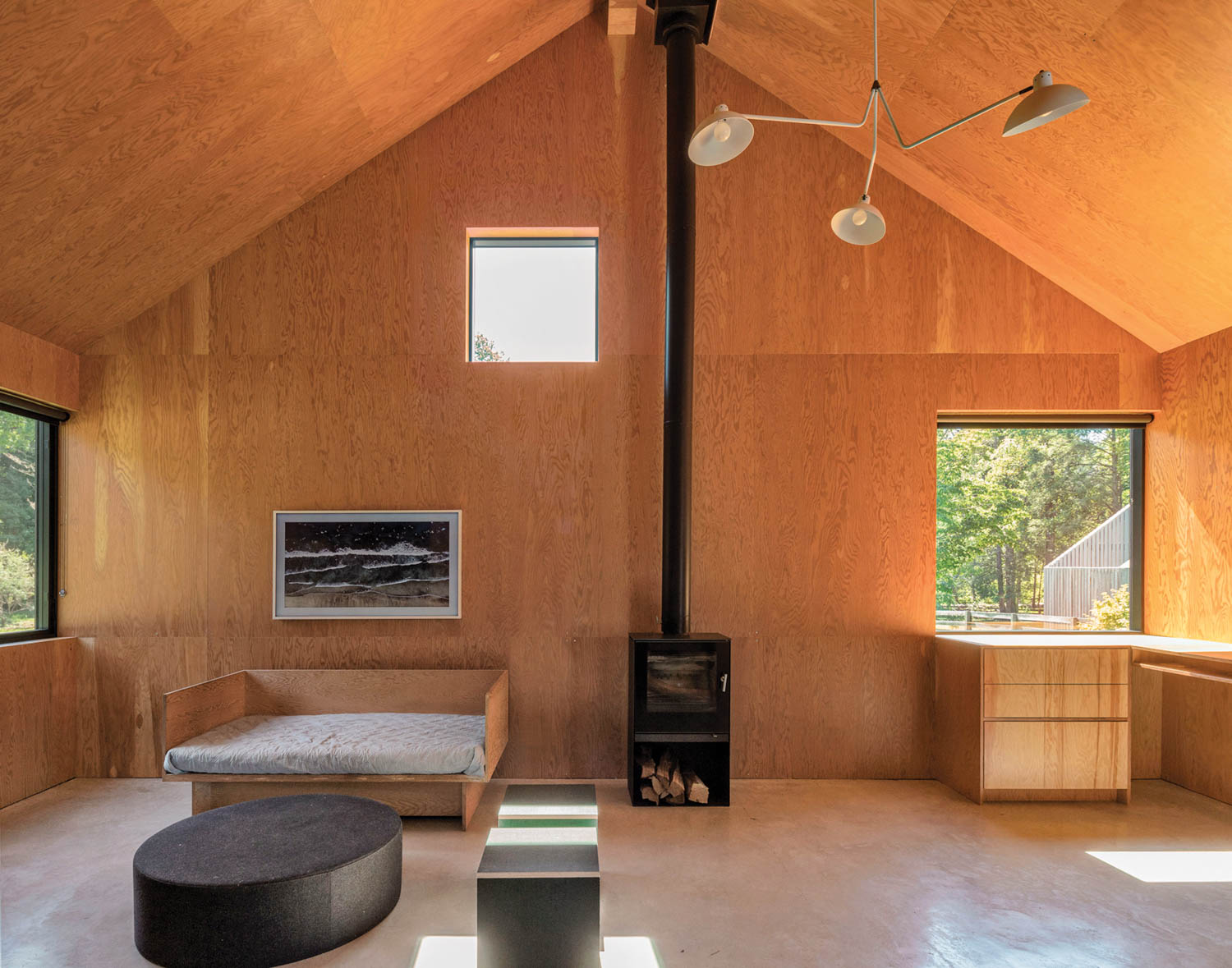 a wood stove centers the family room of a renovated dairy barn, now a house