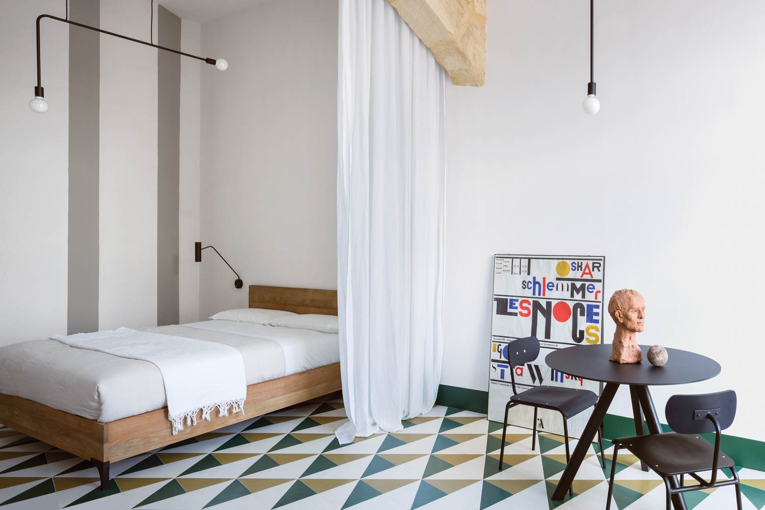 a bed is partitioned off with a sliding curtain atop a green and yellow graphic tile