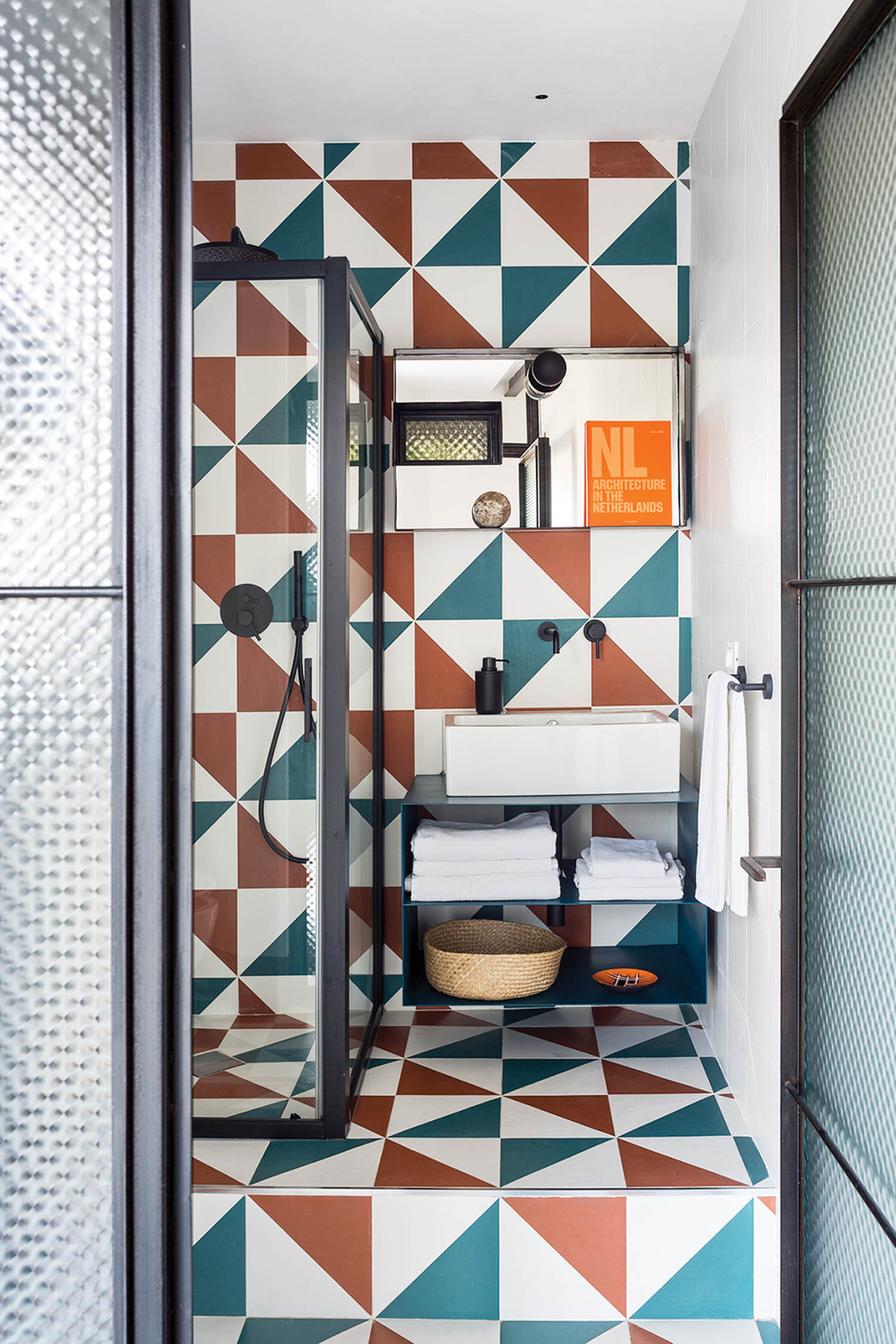 teal and orange graphic tiles mix in the bathroom of a luxury Italian home