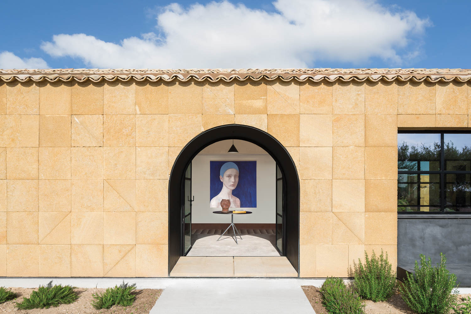 a painted portrait looks out at the arched doorway of this Italian luxury home
