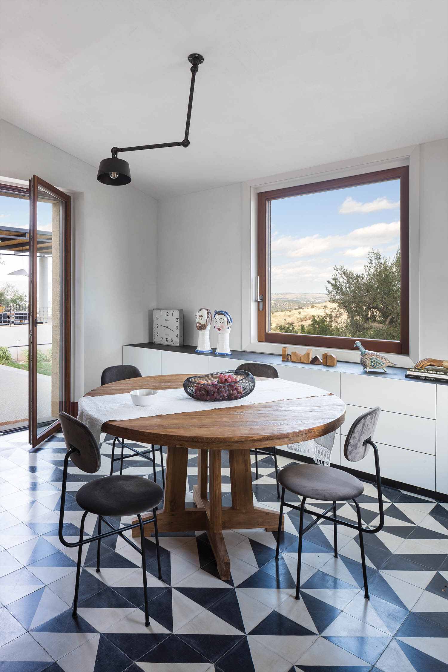 geometric shapes are present in the black and white tile floor of the dining area in an Italian villa