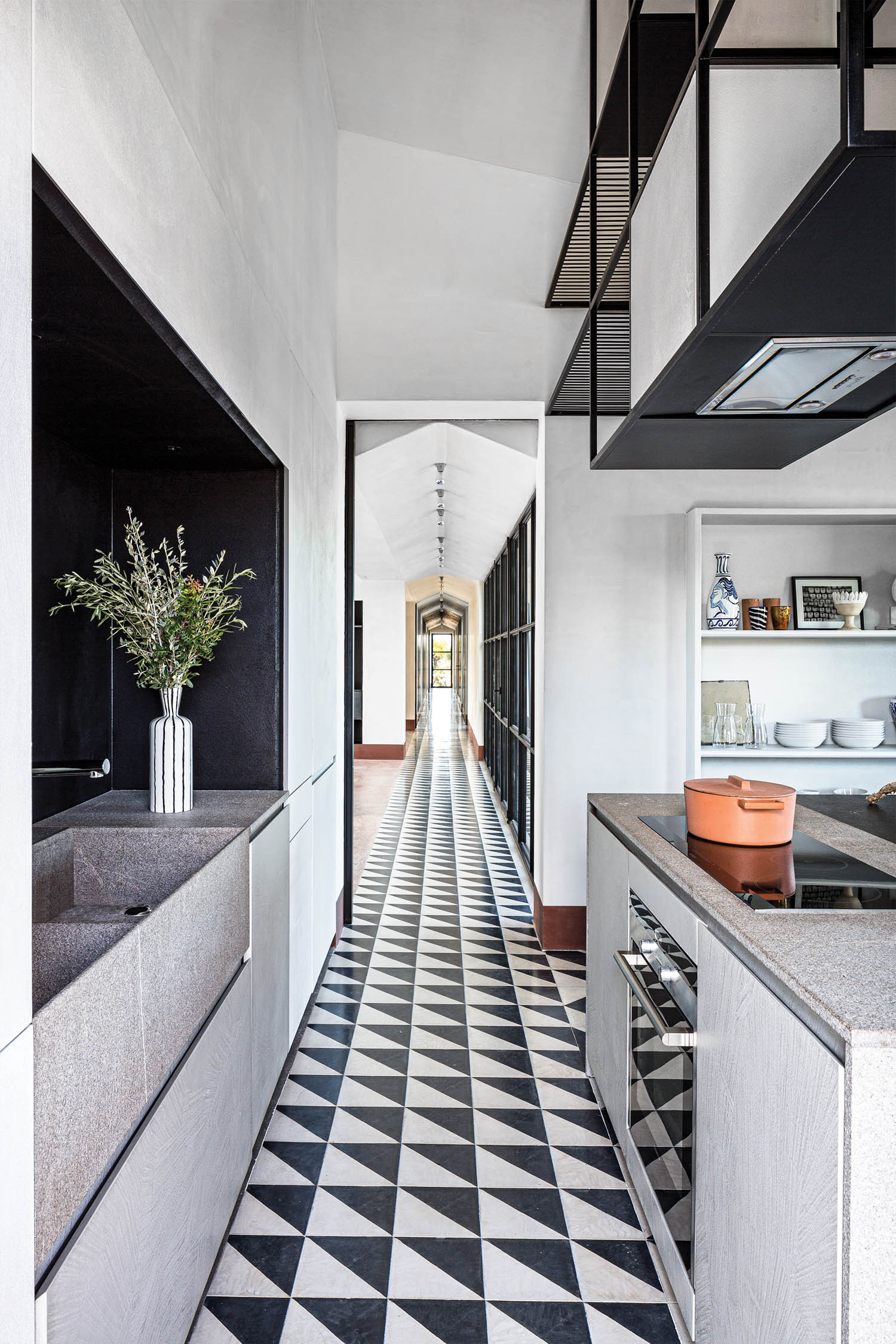 a black and white cement tile hallway from the kitchen to the other side of the house