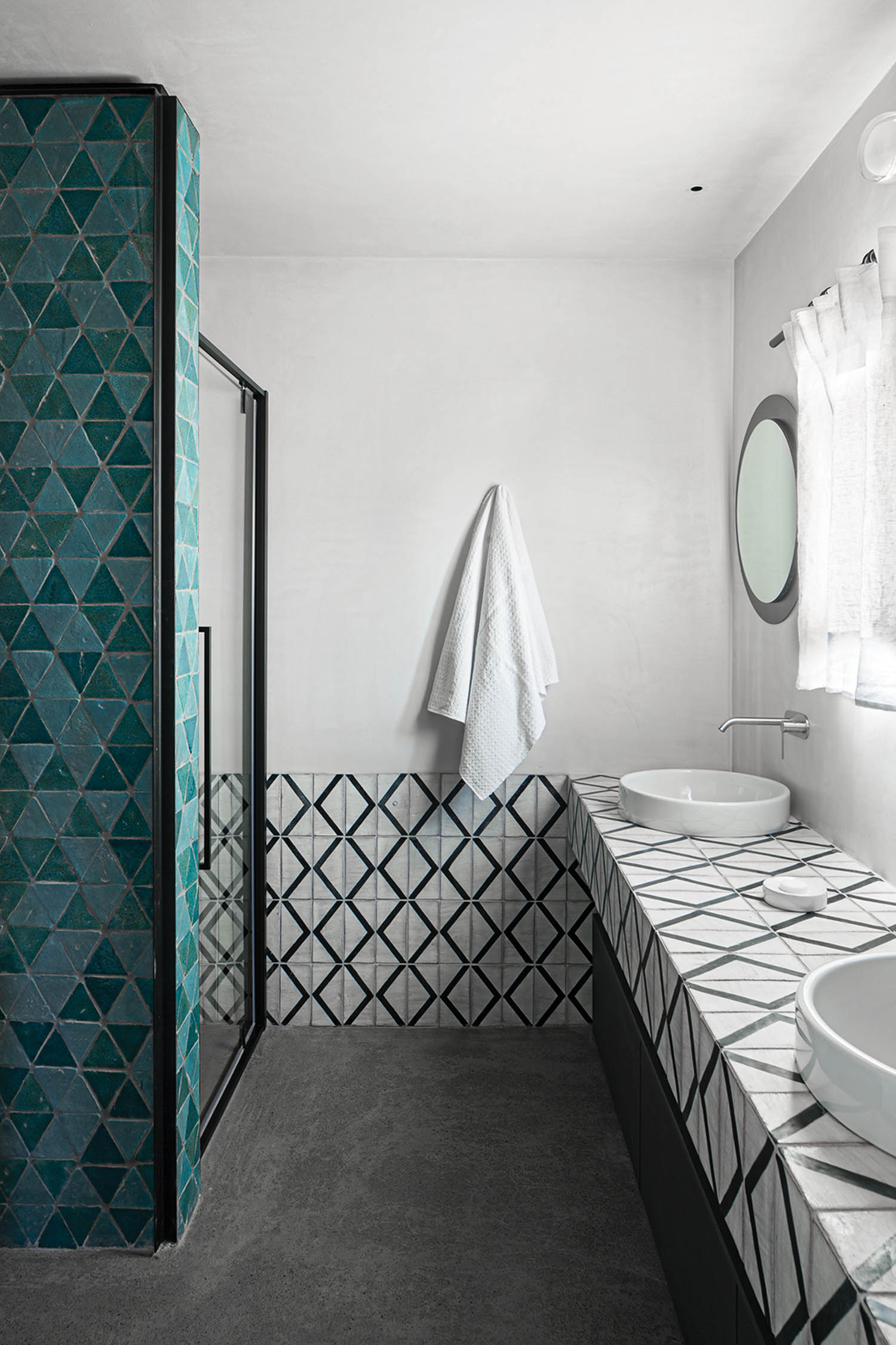 black and white countertops juxtaposed with shades of blue tile on a shower partition