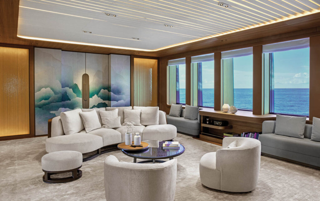 a couch and accent chairs form a seating area inside this yacht suite's sitting room