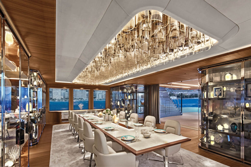 a crystal chandelier hangs above a 10-foot-long dining table