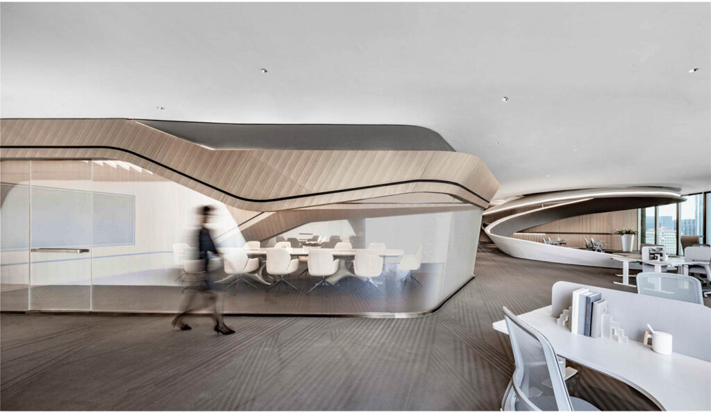 a person walks in front of a conference room in a futuristic office