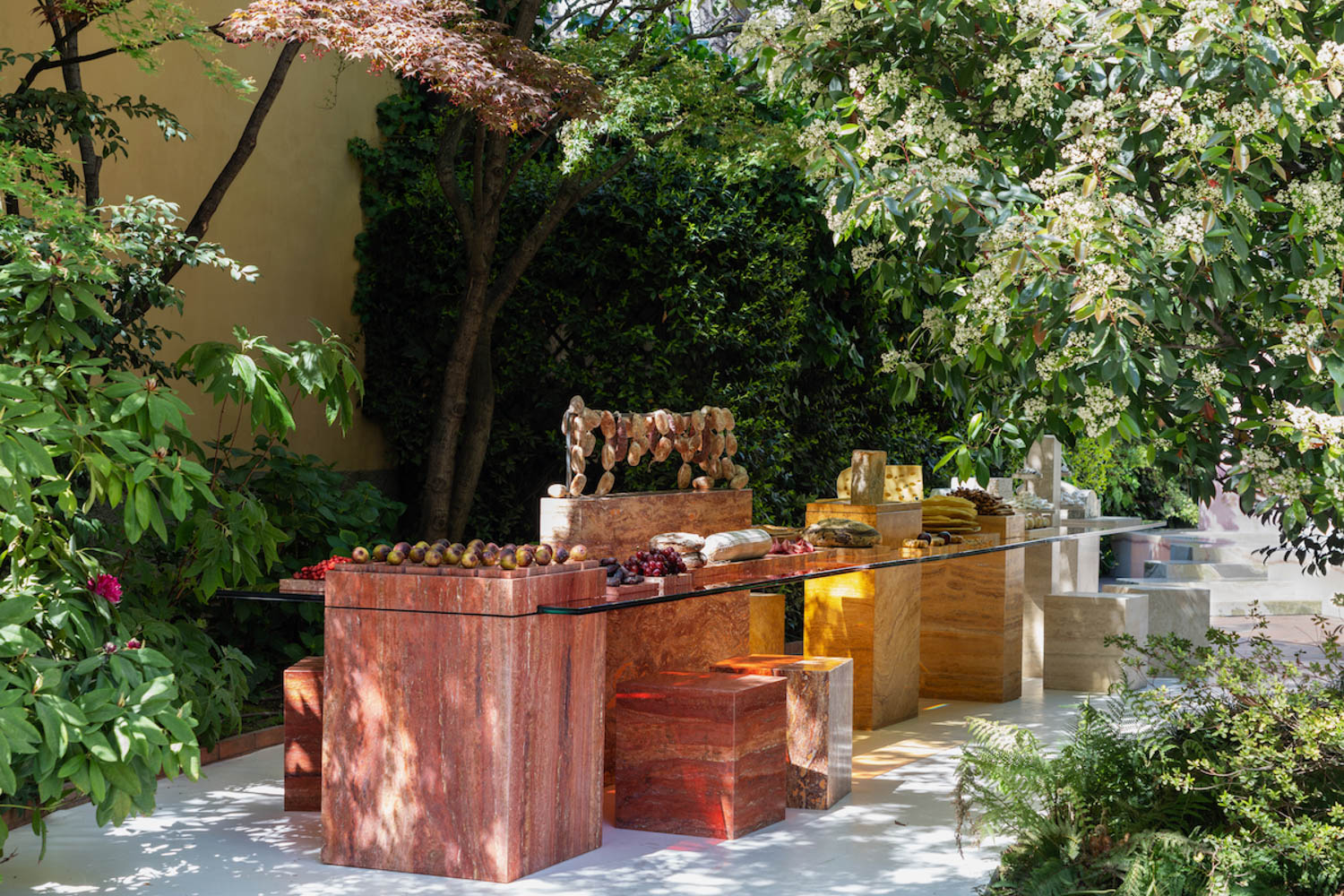 a travertine communal table displays a spread of food