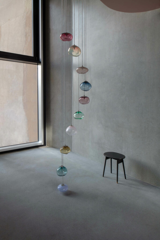 a pendant light like a floating stairway made of colored spheres of glass