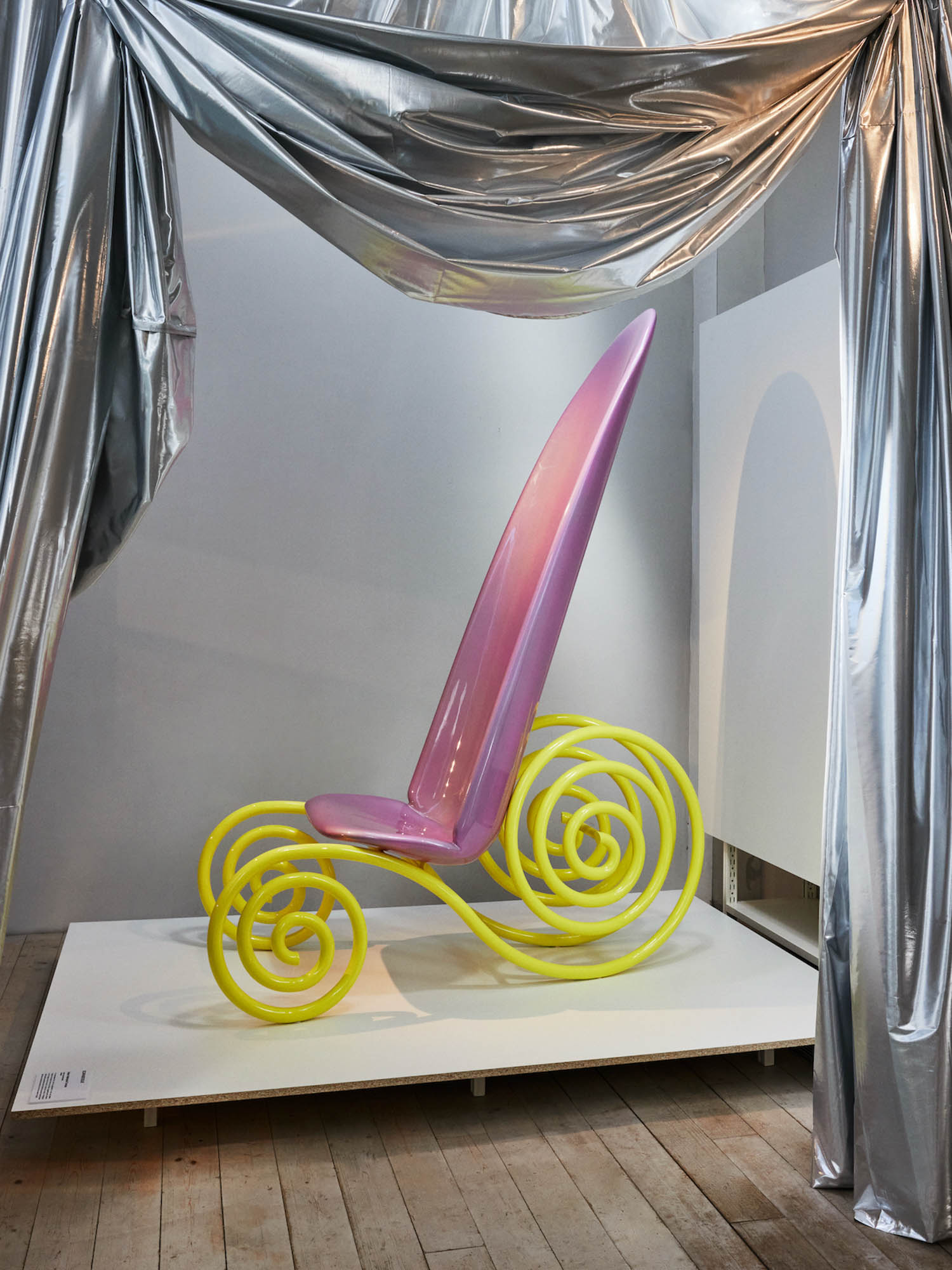 a pink chair with yellow spiral bases