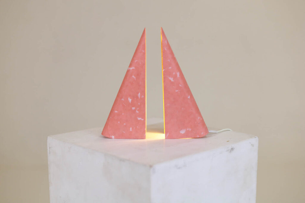a light made of two pink triangular pieces pulled apart
