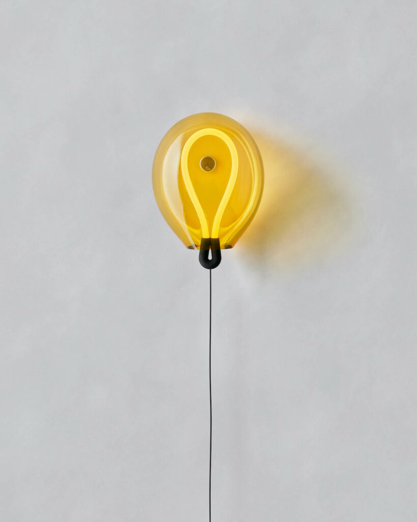 a yellow balloon shaped wall lamp made of light yellow glass