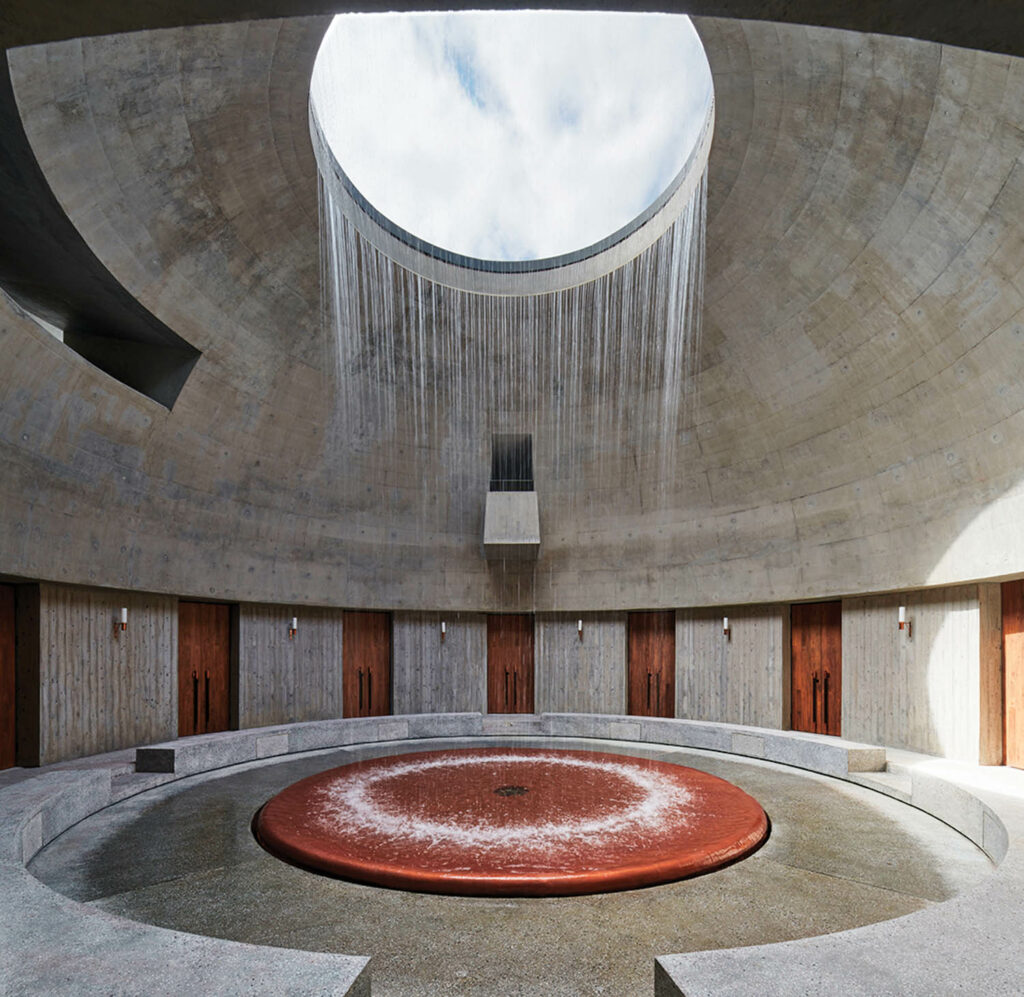 water pours from a skylight in a stone and copper room