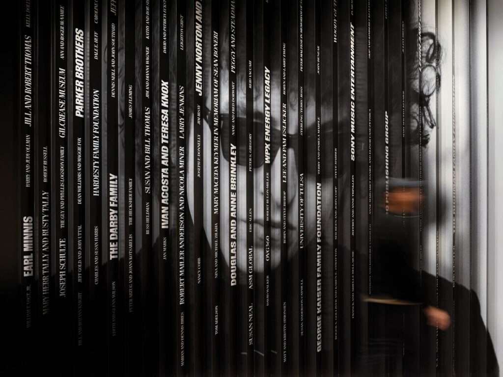 a lenticular wall displays names of donors on one side and, on the other, a 1986 portrait of Bob Dylan by Lisa Law