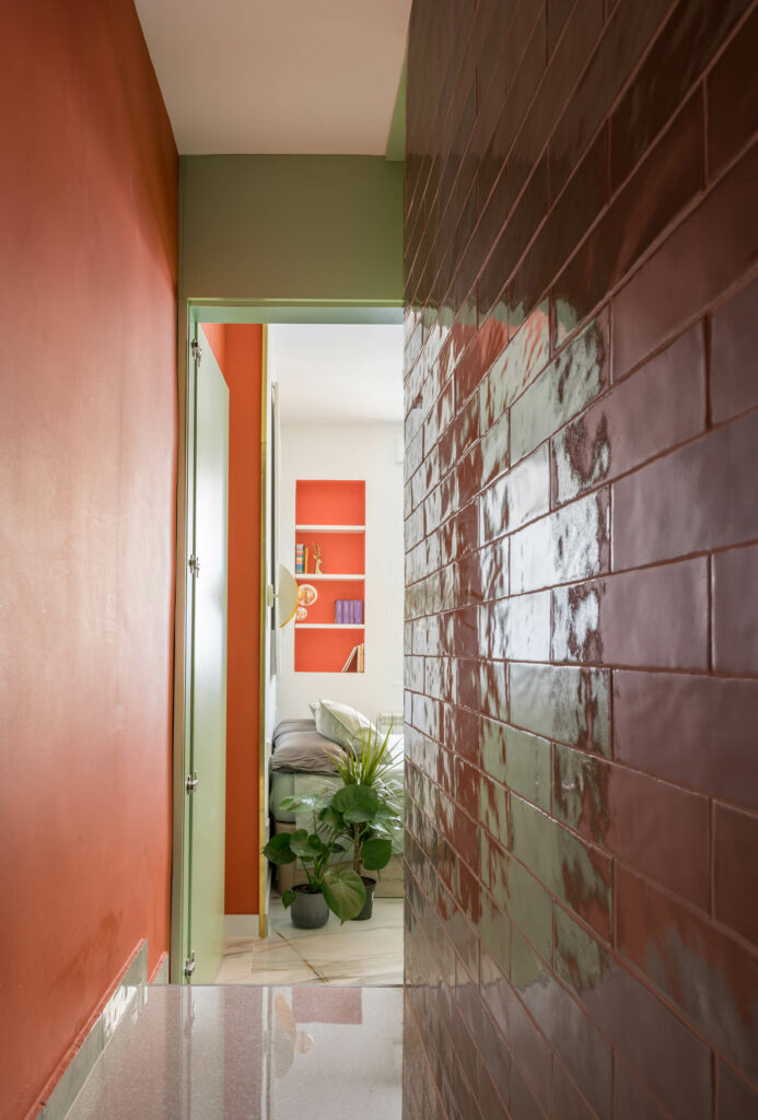 Glossy orange tiles in a hallway of an apartment in Madrid by OOIIO Architecture