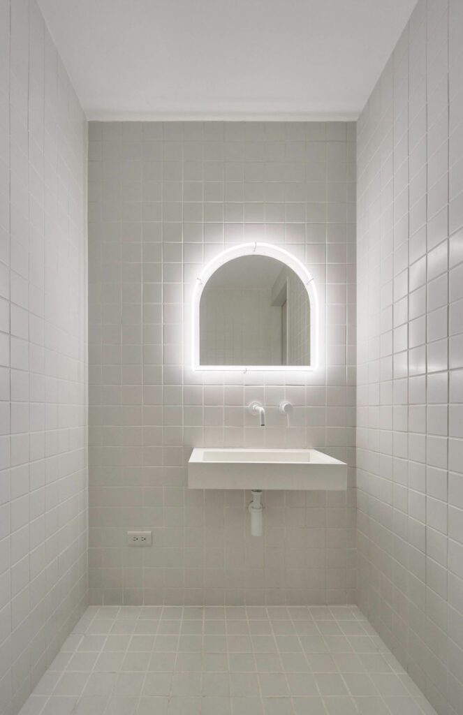 The white-on-white bathroom is clad in field tile.