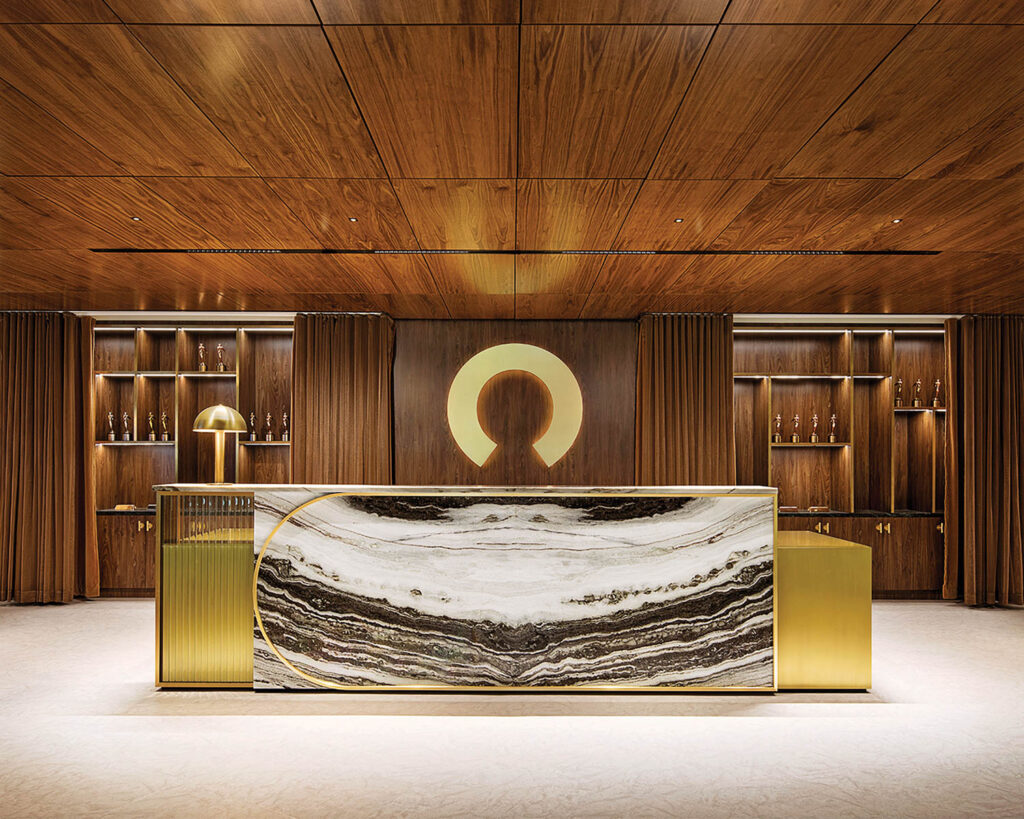 wood paneled ceiling and walls in an entrance area with a gold and marble lobby counter