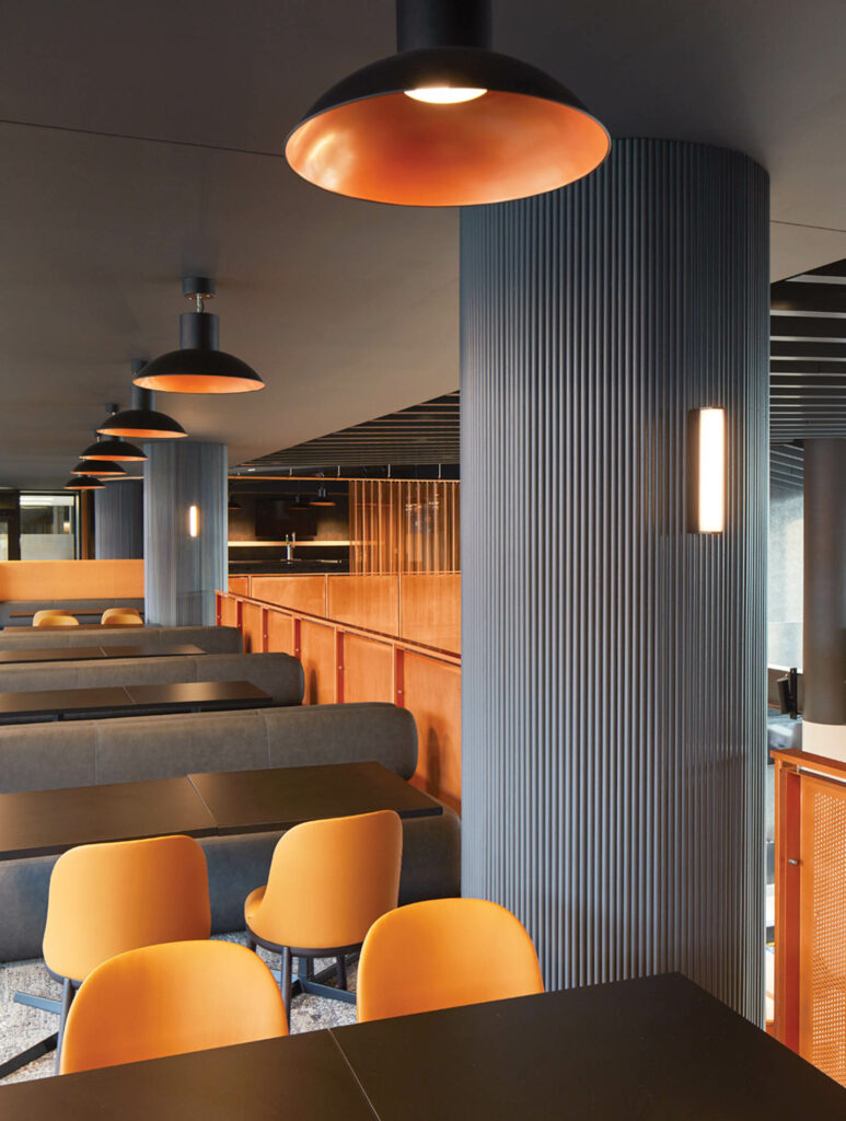 A dining area with orange chairs inside the TQL Stadium