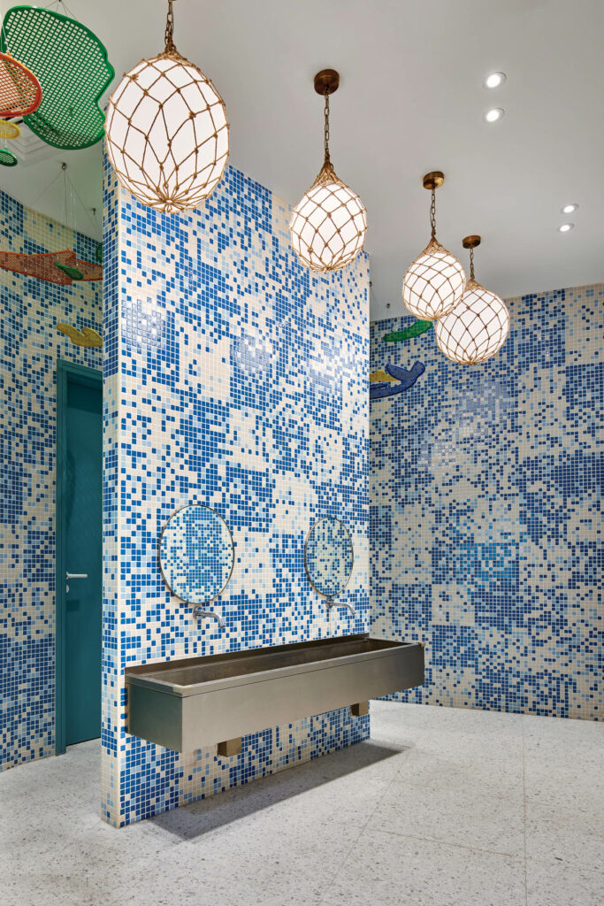 a bathroom with blue and white mosaic tile walls