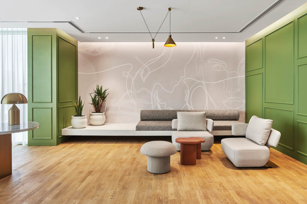 a sitting area with gray seating and green accent walls to the left and right