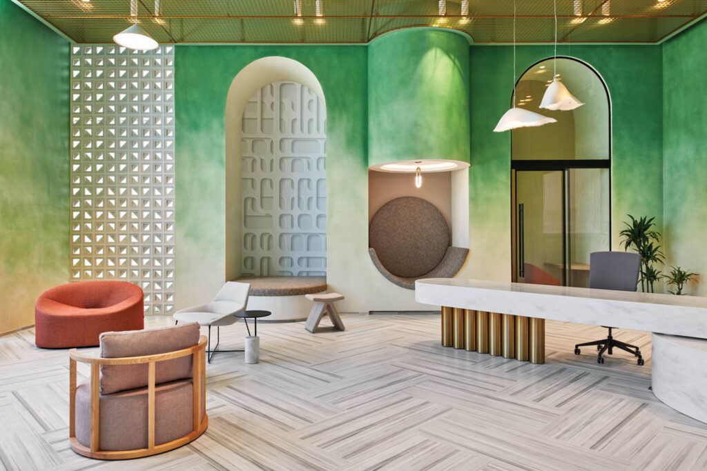 a reception area with green ombre walls and various arch built ins in Abu Dhabi