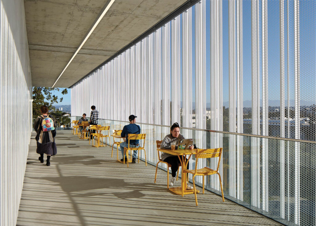 an outdoor corridor with tables and seating outside a university building