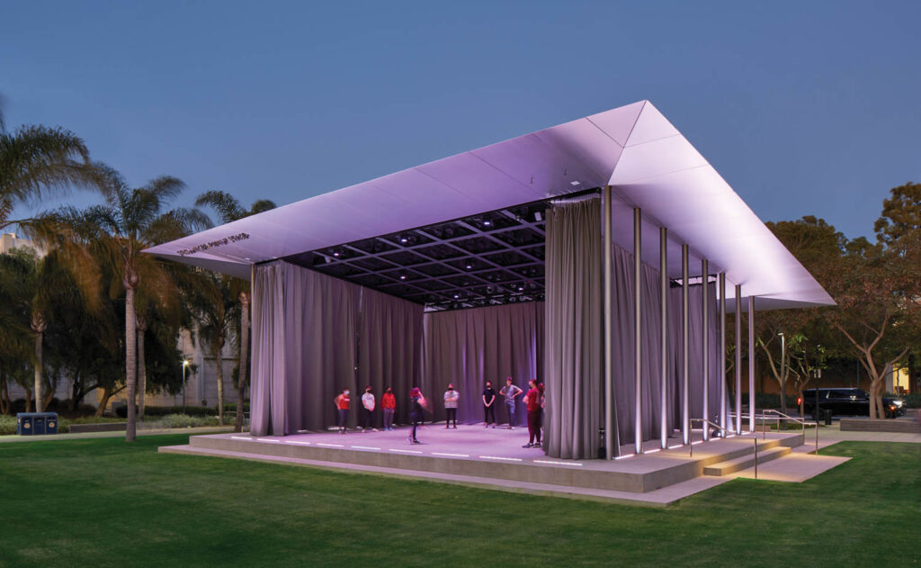 a multipurpose outdoor pavilion glows at night