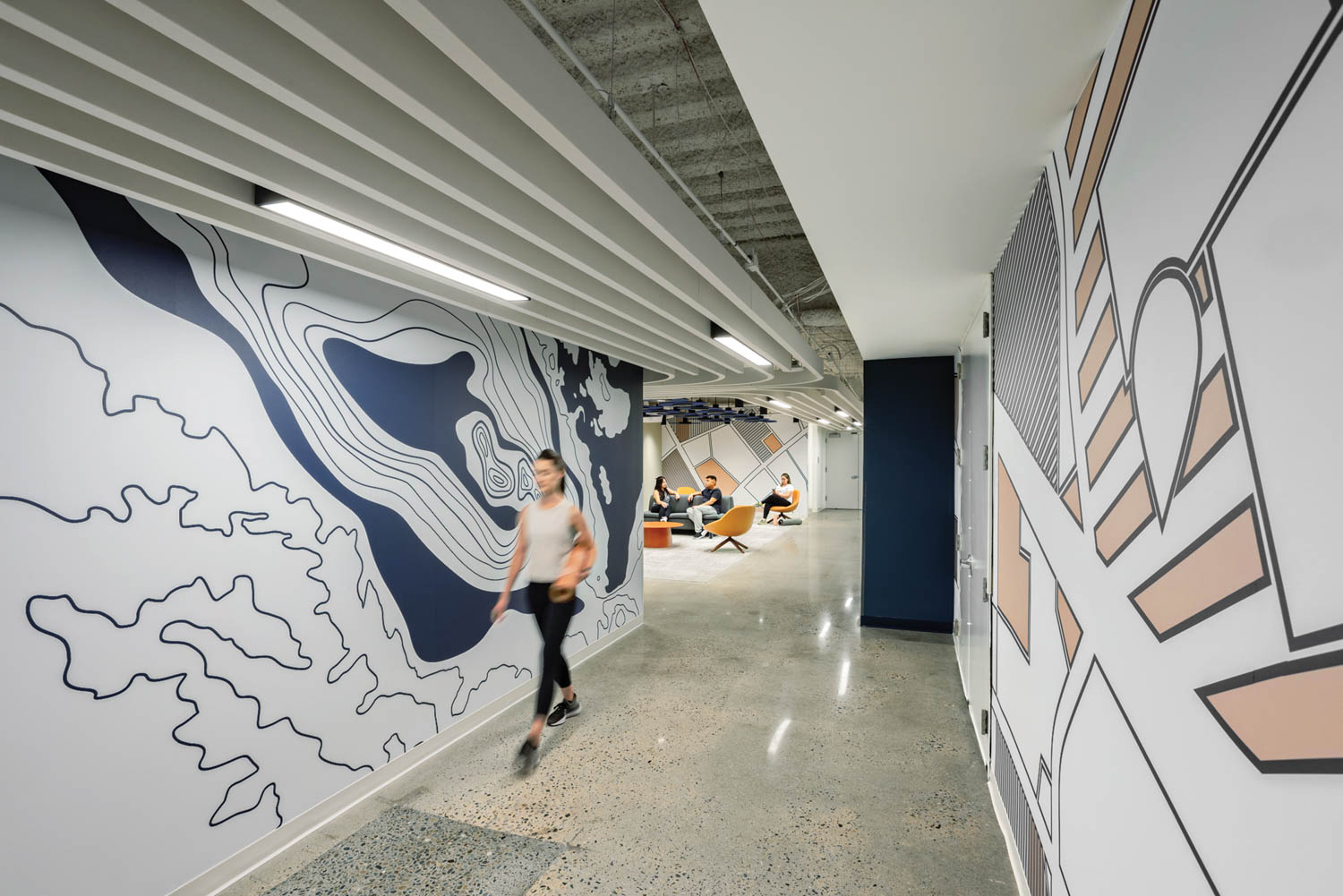 A person walks down a hallways in Santa Clara Towers with a mural on the wall
