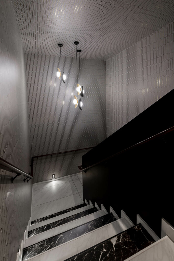 black and white wallcoverings are found in a secret VIP staircase at Superstition, an Austin night club