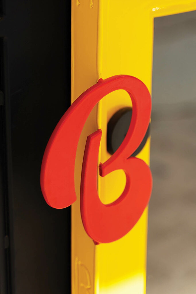 Burger Bodega's logo of a red b on a yellow pole 