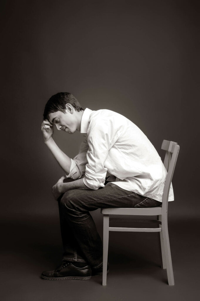 Dmitry Kozinenko, chair designer, in black and white on a chair.